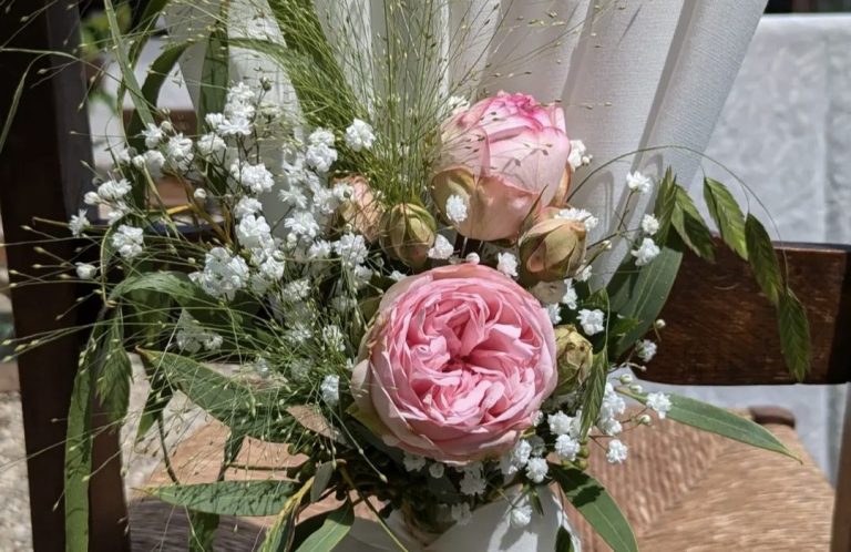 Rosenstrauß mit pinken und weißen Blüten, umgeben von Grün und Gipskraut.